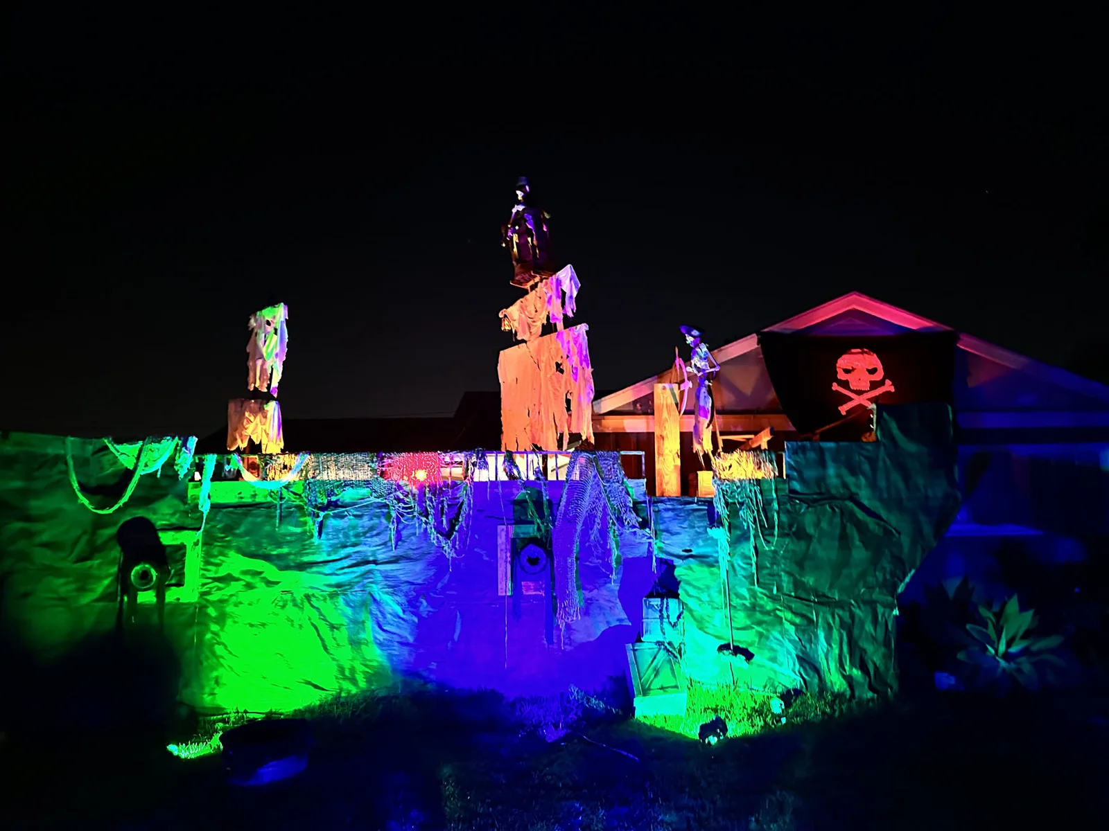 Seville Manor's facade lit green, purple, and orange on Halloween night